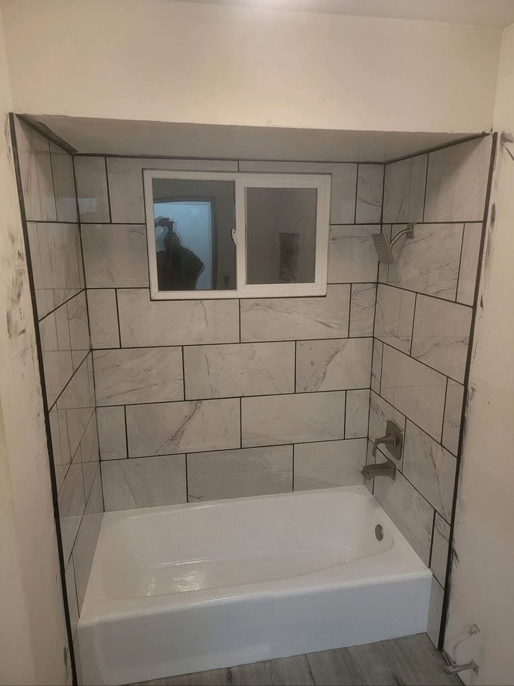 Bathroom after: full marble-look tile surround